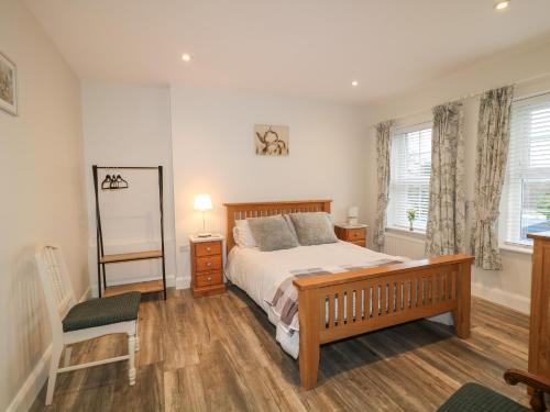 a bedroom with a bed and a chair and windows at Sliabh Amharc in Downpatrick