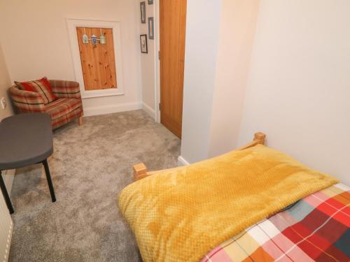 a bedroom with a bed and a chair and a door at Sliabh Amharc in Downpatrick
