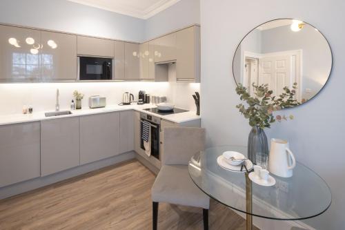 a kitchen with a glass table and a mirror at Redmayne House - Urban Apartments in Bristol