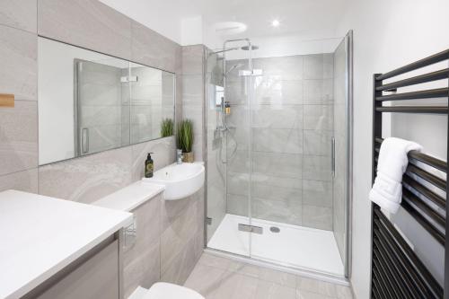 a bathroom with a shower and a toilet and a sink at Redmayne House - Urban Apartments in Bristol