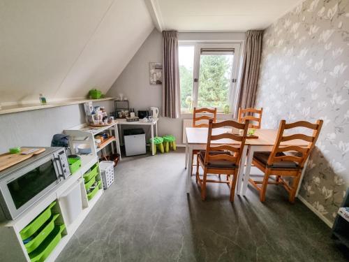 a kitchen and dining room with a table and chairs at B&B overnachting de Margriet in Hardenberg