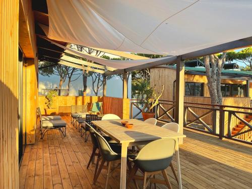 a patio with a table and chairs on a deck at Apartamentos Biopasivos Living Pura Madera in Chiclana de la Frontera