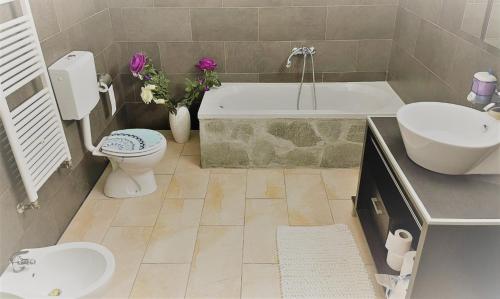 La salle de bains est pourvue d'une baignoire, de toilettes et d'un lavabo. dans l'établissement Casa Landoni, à Mendrisio