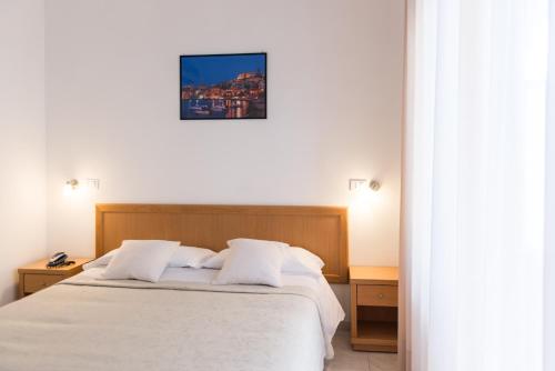 a bedroom with a white bed with two night stands at Hotel Viola in Gaeta