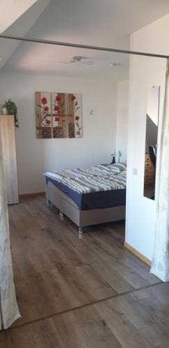 Schlafzimmer mit einem Bett und Holzboden in der Unterkunft Oktopus in Hannover