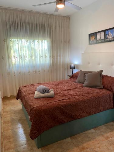 a bedroom with a bed with a red blanket and a window at PLATANERA apart in Calafell