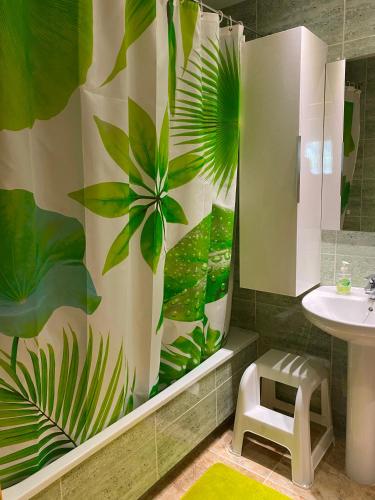 a bathroom with a shower curtain with a plant pattern at PLATANERA apart in Calafell