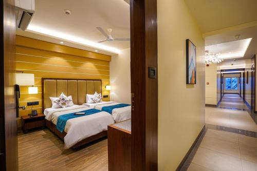 a hotel room with a large bed and a hallway at Hotel El Magnifico in Surat