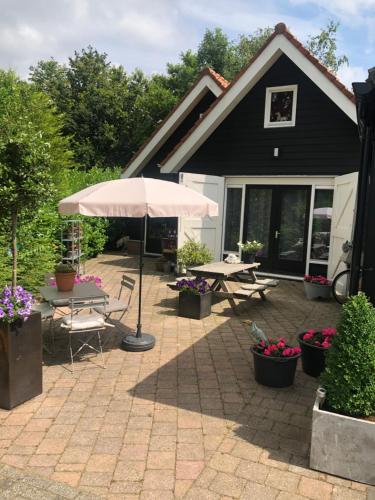 a patio with a table and an umbrella at De vrienden van Sir in Sirjansland