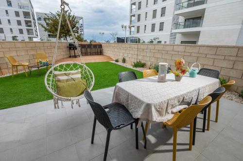 a patio with a table and chairs and a yard at Achziv Sea&Sun in Nahariyya