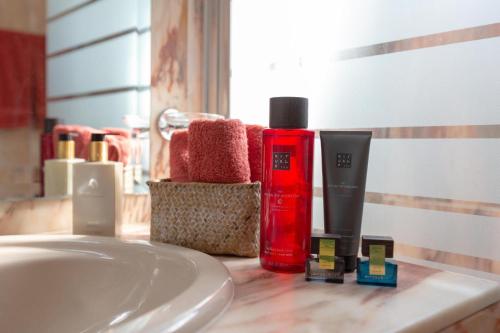 a bathroom counter with a sink and a red bottle of soap at Beach apartment La Cala in La Cala de Mijas
