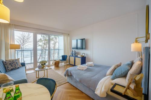 a bedroom with a bed and a living room at Sunnyway Apartment in Ustronie Morskie