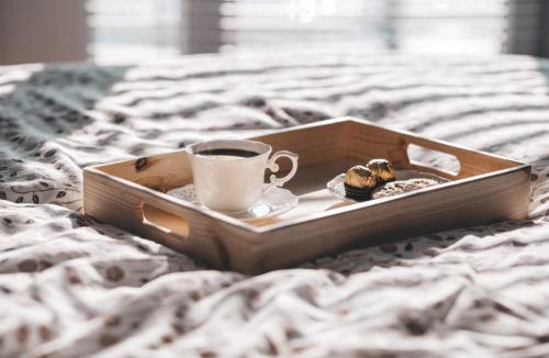a tray with a cup of coffee and cookies on a bed at SCF Collection - Duomo in Milan