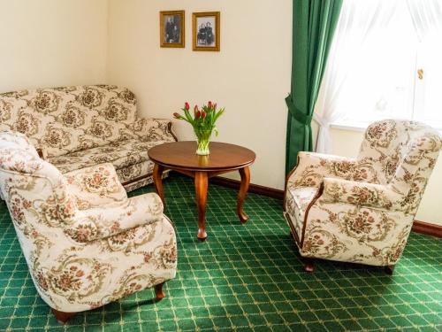 a living room with two chairs and a table at Pałac Godętowo in Łęzyce