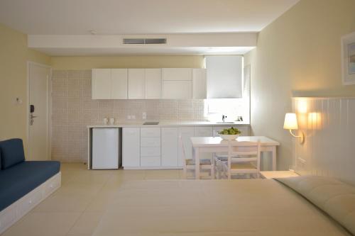 a kitchen and living room with a table and chairs at Sunrise Gardens Aparthotel in Protaras