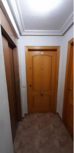 a hallway with a wooden door in a room at Apartamentos La Paz VIII in Torrevieja