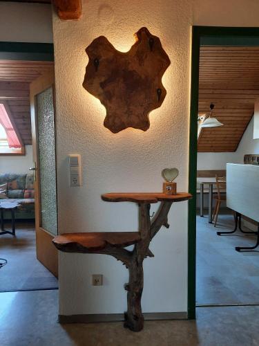 a table in a room with a wall with a tree branch on it at Mockenhof in Argenbühl