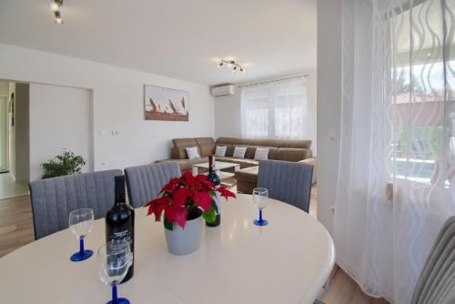 a white table with two wine bottles and flowers on it at Holiday Home Petar by Rent Istria in Buje