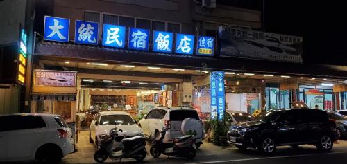 a group of cars and scooters parked in front of a building at 日月潭大統民宿 in Yuchi