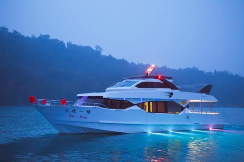 a white yacht in the water at night at 日月潭大統民宿 in Yuchi