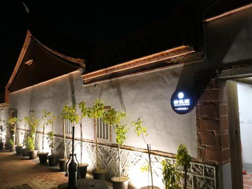 a row of potted plants on a wall at 新龍頭古厝行館 Shin Long Tou B&B in Jinning