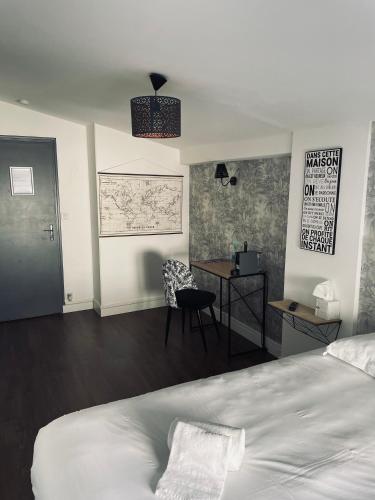 a bedroom with a bed and a desk and a table at logis Paul Massy in Meschers-sur-Gironde