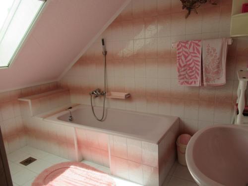 een roze badkamer met een bad en een wastafel bij Vízközeli nyaralo 6 fo reszere Velencen VCE-7 in Buhinpuszta