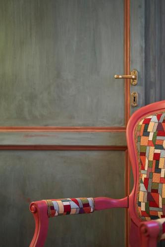 a red chair sitting in front of a door at Alla Scala 1746 in Siena