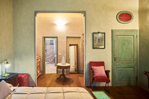 a bedroom with a bed and a table and a chair at Alla Scala 1746 in Siena