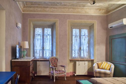 a room with two windows and a desk and a chair at Alla Scala 1746 in Siena