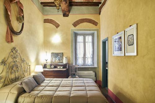 a bedroom with a large bed and a desk at Alla Scala 1746 in Siena
