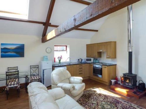 a living room with a white couch and a kitchen at Surprise View in Holmrook