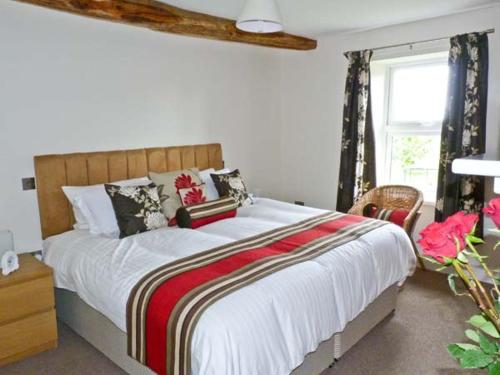 - une chambre avec un grand lit et une fenêtre dans l'établissement Chimney Gill, à Sebergham