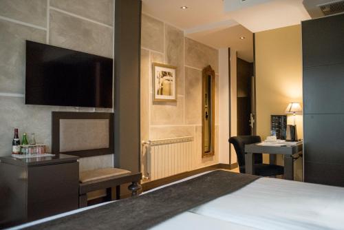 a hotel room with a bed and a desk at Costa Esmeralda Suites in Suances