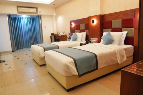 a hotel room with two beds in a room at Nascent Gardenia Residence in Dhaka