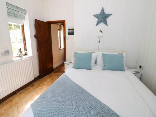 a bedroom with a large bed with a blue star on the wall at Fox Cottage in Droitwich