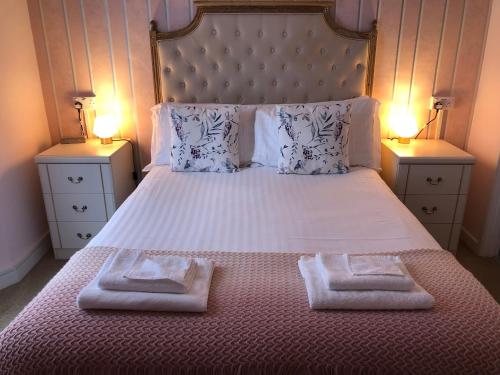 a bedroom with a bed with two towels on it at Bella Vista Hotel in Weston-super-Mare