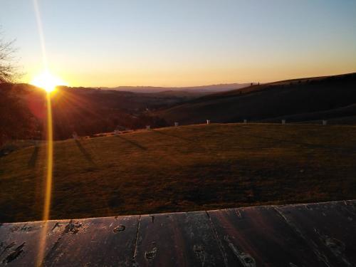a sunset on top of a field with the sun setting at Mount Shekinah Country Hotel in Balgowan