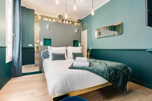 a bedroom with a large bed with blue walls at The Charming Trocadero Eiffel Tower in Paris