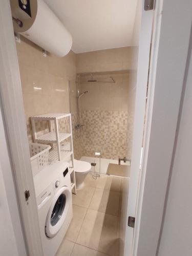 ein Badezimmer mit einer Waschmaschine und einem Waschbecken in der Unterkunft Apartamento en primera línea de playa A - Marbella Centro in Marbella