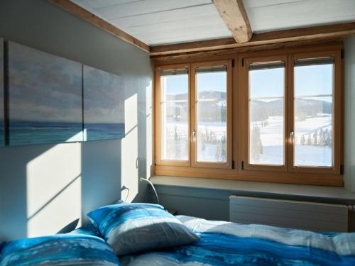 a bedroom with a bed and a window at Jurabelle in La Côte-aux-Fées