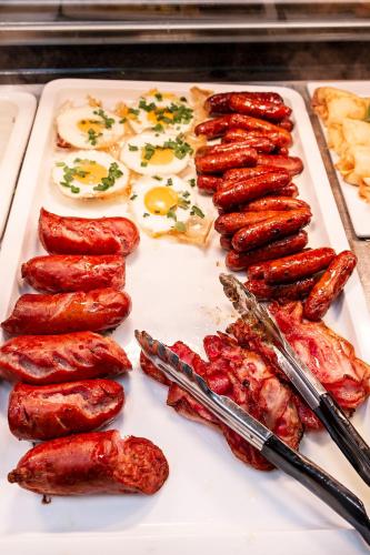 a tray of sausages and eggs on a table at Hotel Picaro Kraśnik Dolny in Bolesławiec
