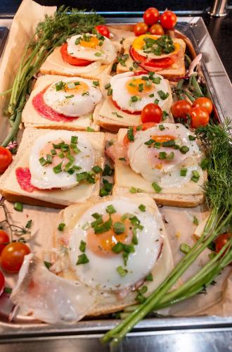a tray of eggs on toast with tomatoes and greens at Hotel Picaro Kraśnik Dolny in Bolesławiec