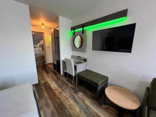 a living room with a table and a green light at Hotel Nap in West-Terschelling