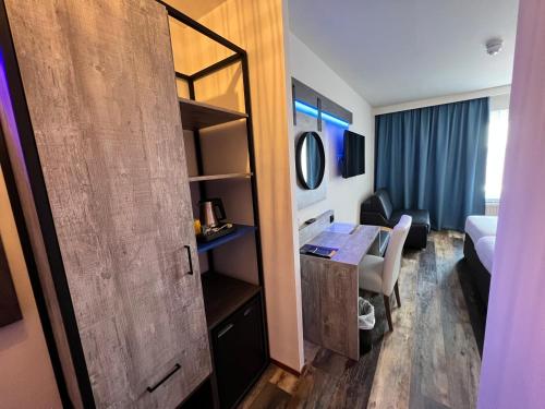 a hotel room with a desk and a room with a bed at Hotel Nap in West-Terschelling