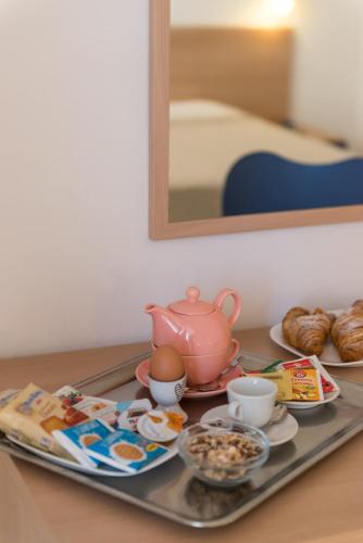 a tray with a tea pot and food on a table at Hotel Viola in Gaeta