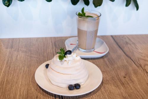 a cake sitting on a table with a drink at Hotel Picaro Kraśnik Dolny in Bolesławiec