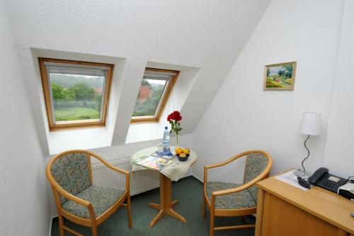 a room with a table and two chairs and a desk at Pension Schwark in Bad Doberan