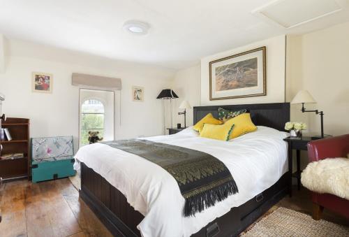 a bedroom with a large bed with yellow pillows at Church Cottage in Chipping Norton