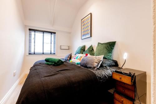 a bedroom with a large bed with green pillows at Modern 2 Bedroom Queen Street Apartment in Norwich